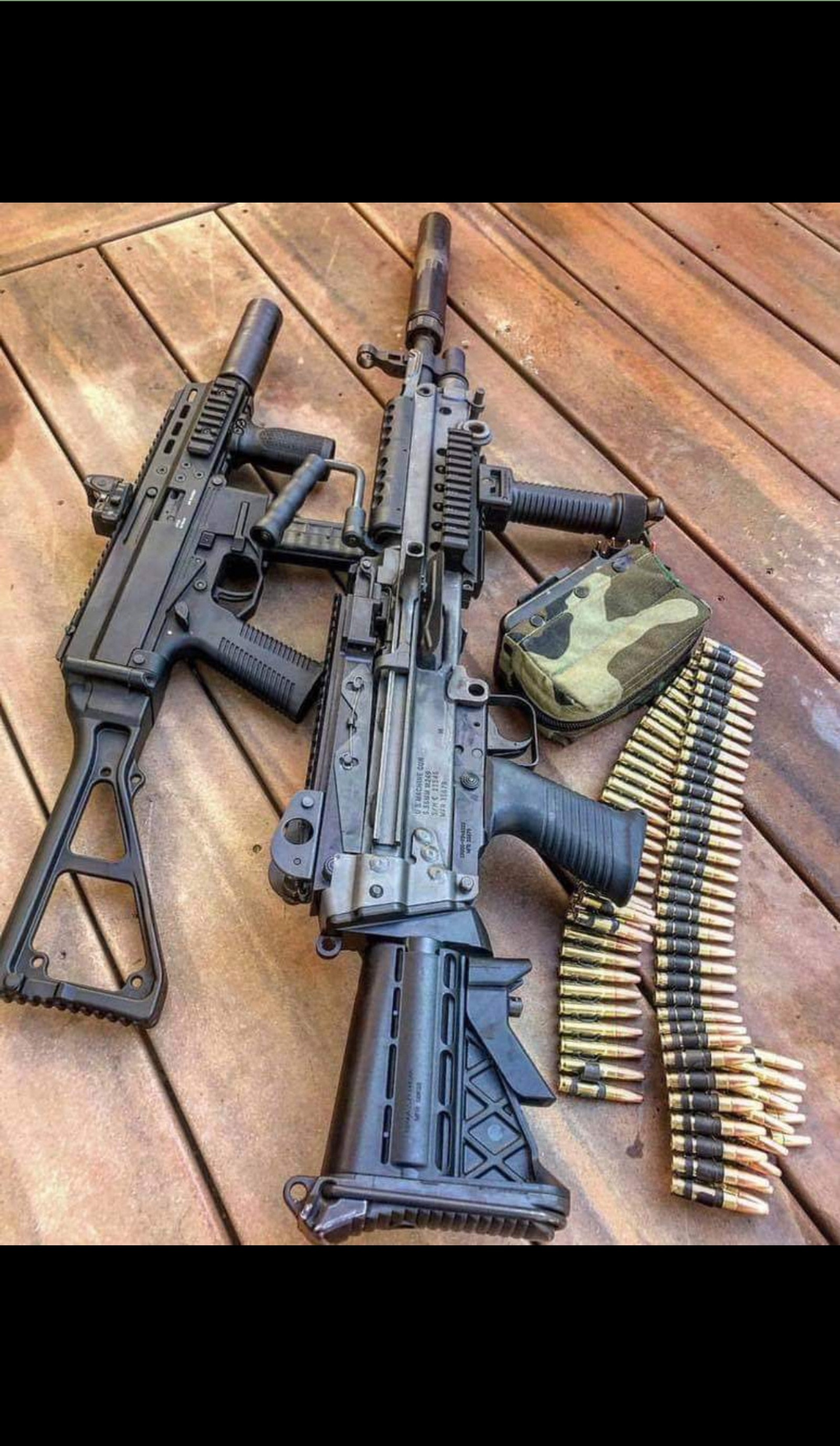 A close up of a rifle and other weapons on a wooden floor (army, colt, gun, military, rifle)