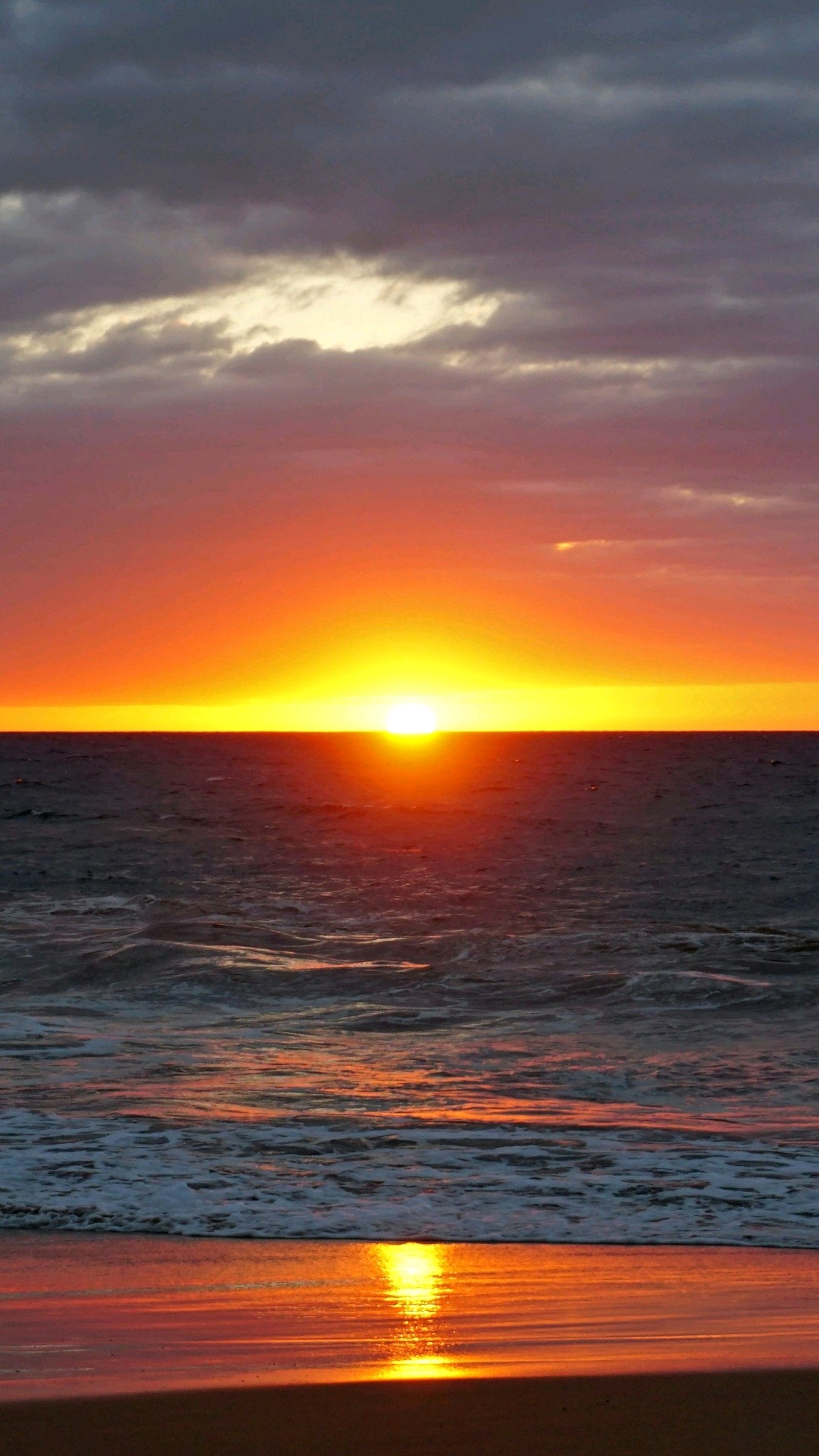 Sunset over the ocean with a surfer walking on the beach (4k, nature, sea)