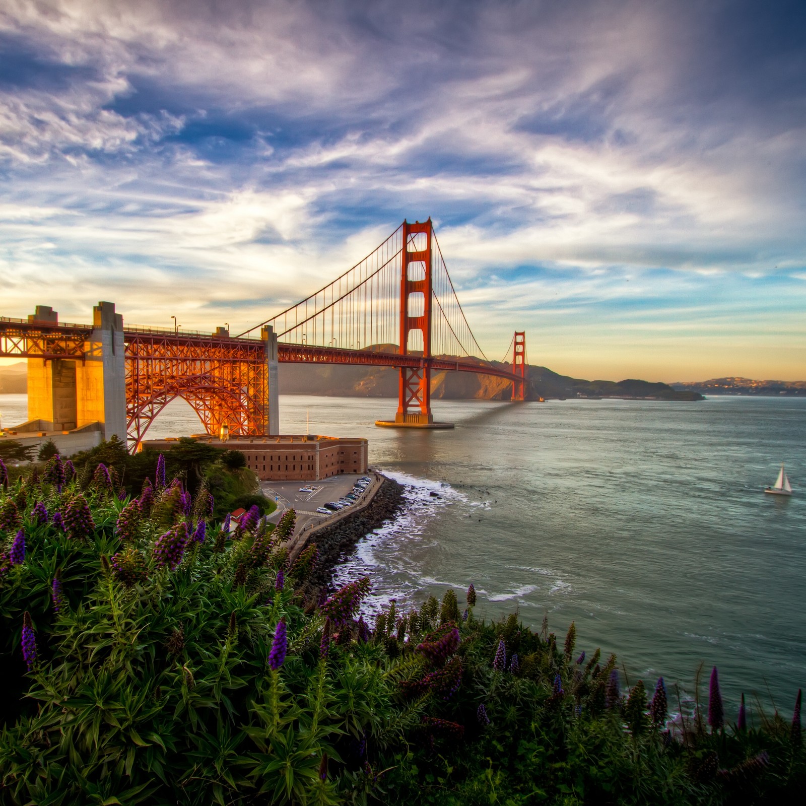 Arafed view of a bridge and a body of water with a sailboat in the water (golden gate bridge, bridge, suspension bridge, landmark, sea)