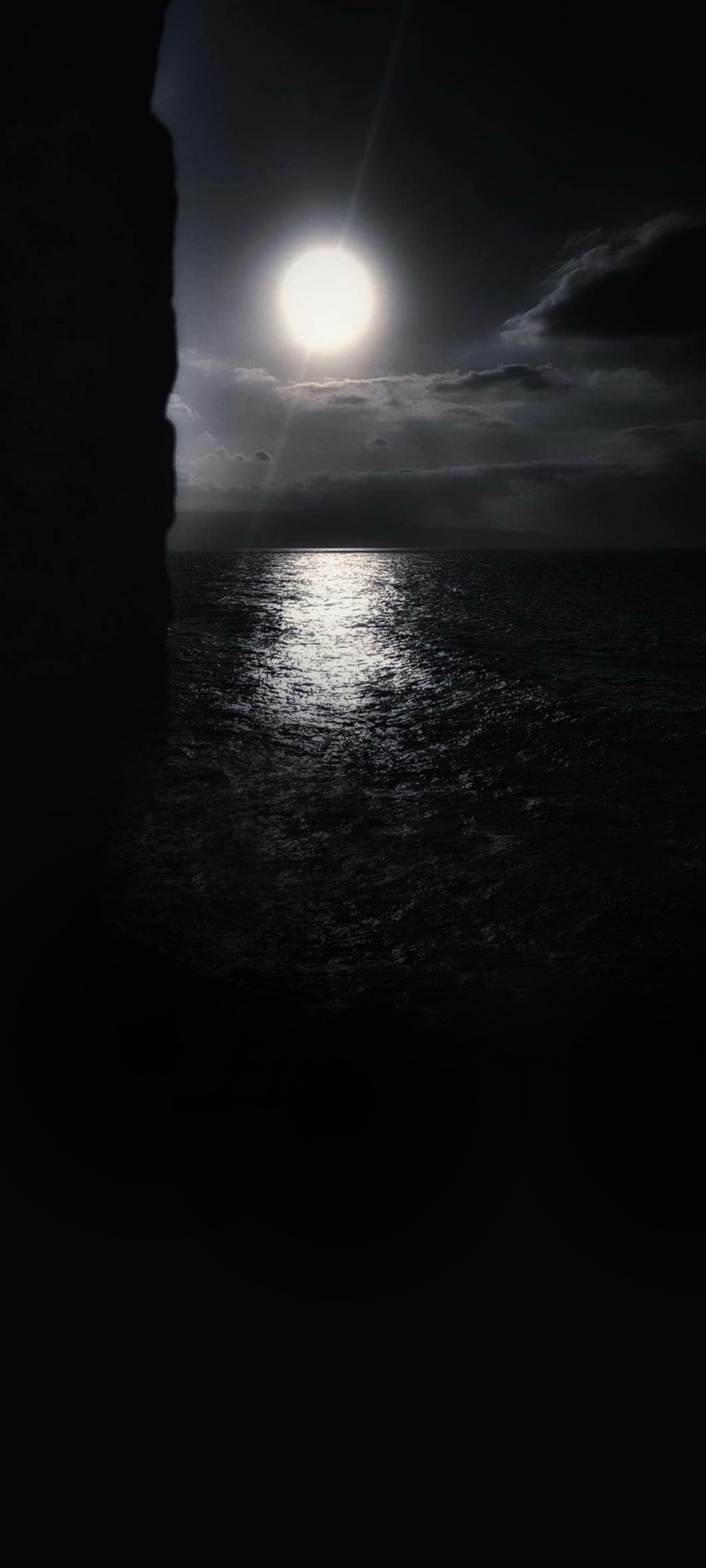 Una vista de la luna llena brillando sobre el océano (luz de luna, blanco y negro, luna llena, agua, nube)