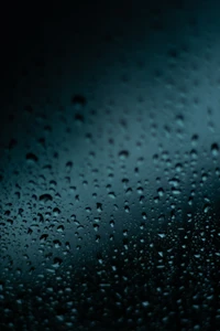 Close-up de gotas de chuva em uma superfície escura