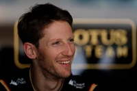 Romain Grosjean souriant dans le garage de l'équipe Lotus