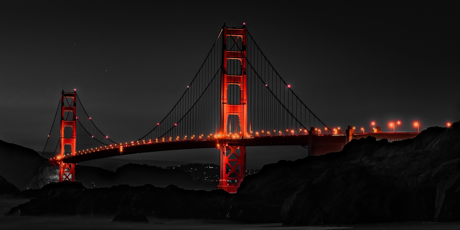 Um close de uma ponte com luzes nela à noite (ponte golden gate, golden gate bridge, noite, monocromático, fundo escuro)