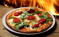 Pizza assada em forno a lenha coberta com espinafre e tomates secos ao sol, com um fundo de chamas.