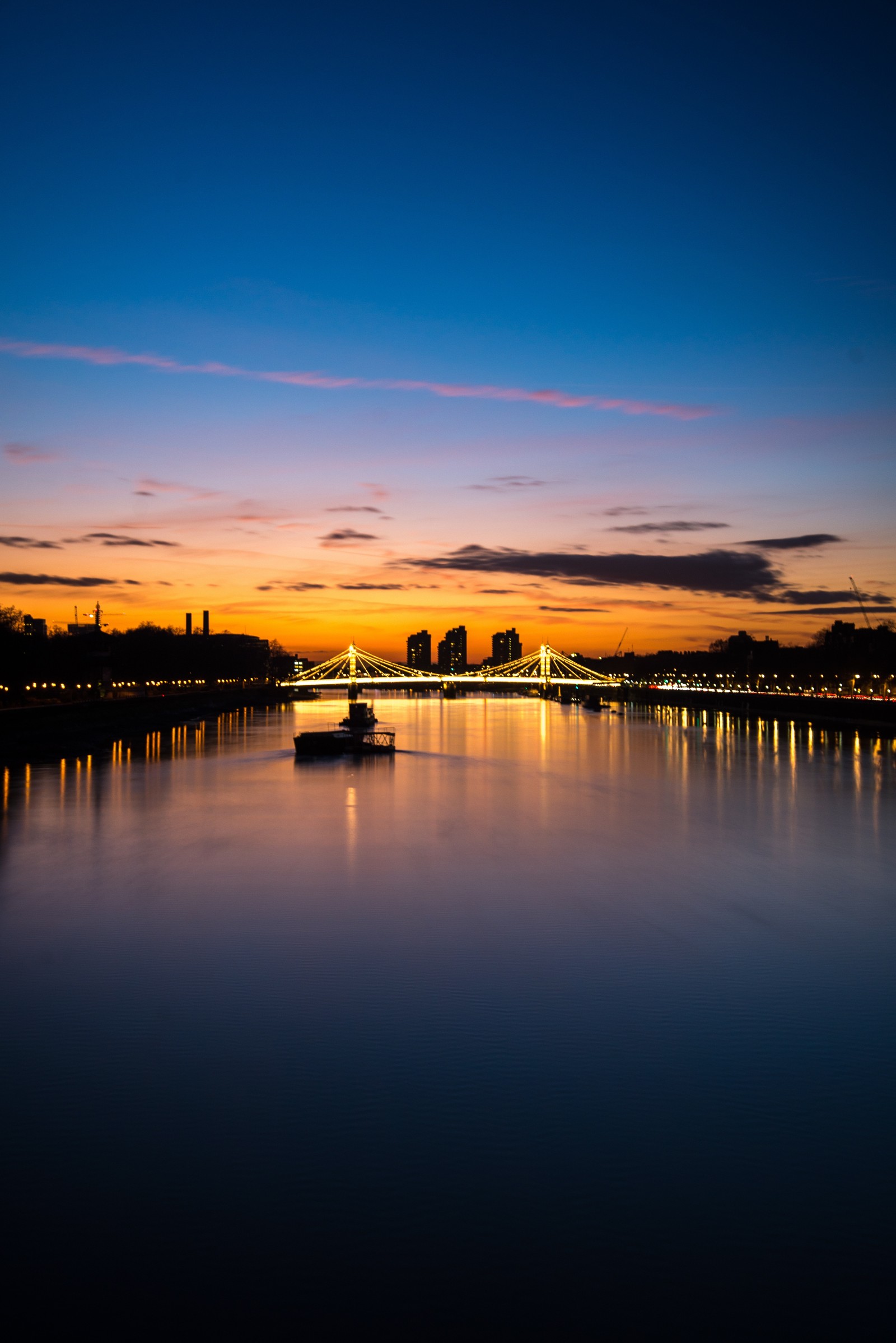 Arafed view of a boat on a river at sunset (london, reflection, water, horizon, nature)