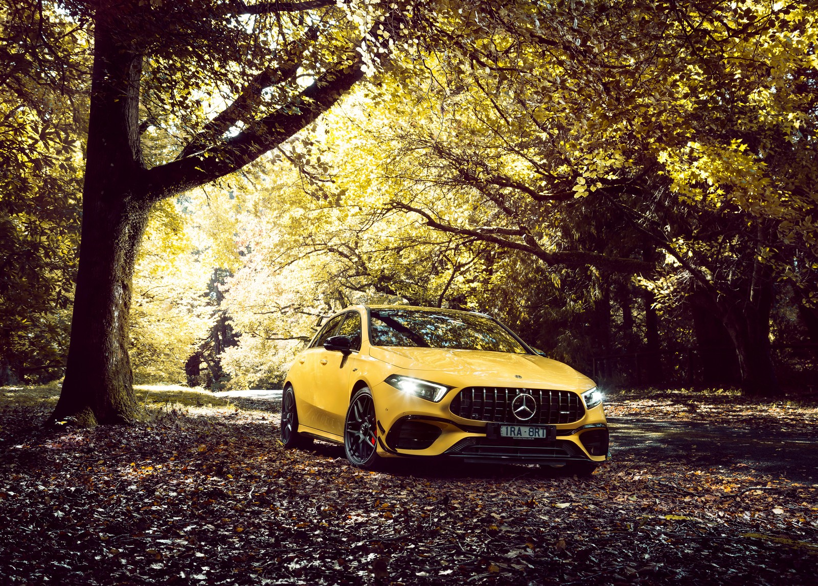 A yellow mercedes car parked in the middle of a forest (mercedes amg a 45 s 4matic, aerodynamic package, fall, 2020, cars)