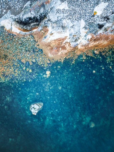 Безмятежный вид с воздуха на зимний пейзаж с чистой водой и скалистым берегом