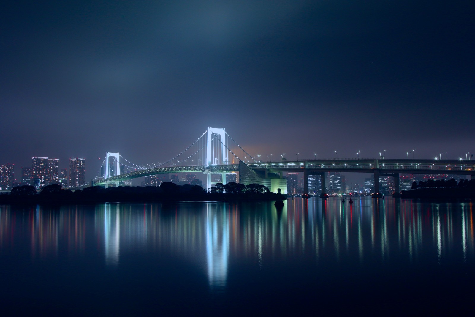 Vista aérea de uma ponte sobre um corpo d'água à noite (ponte arco íris, tóquio, tokyo, japão, noite)