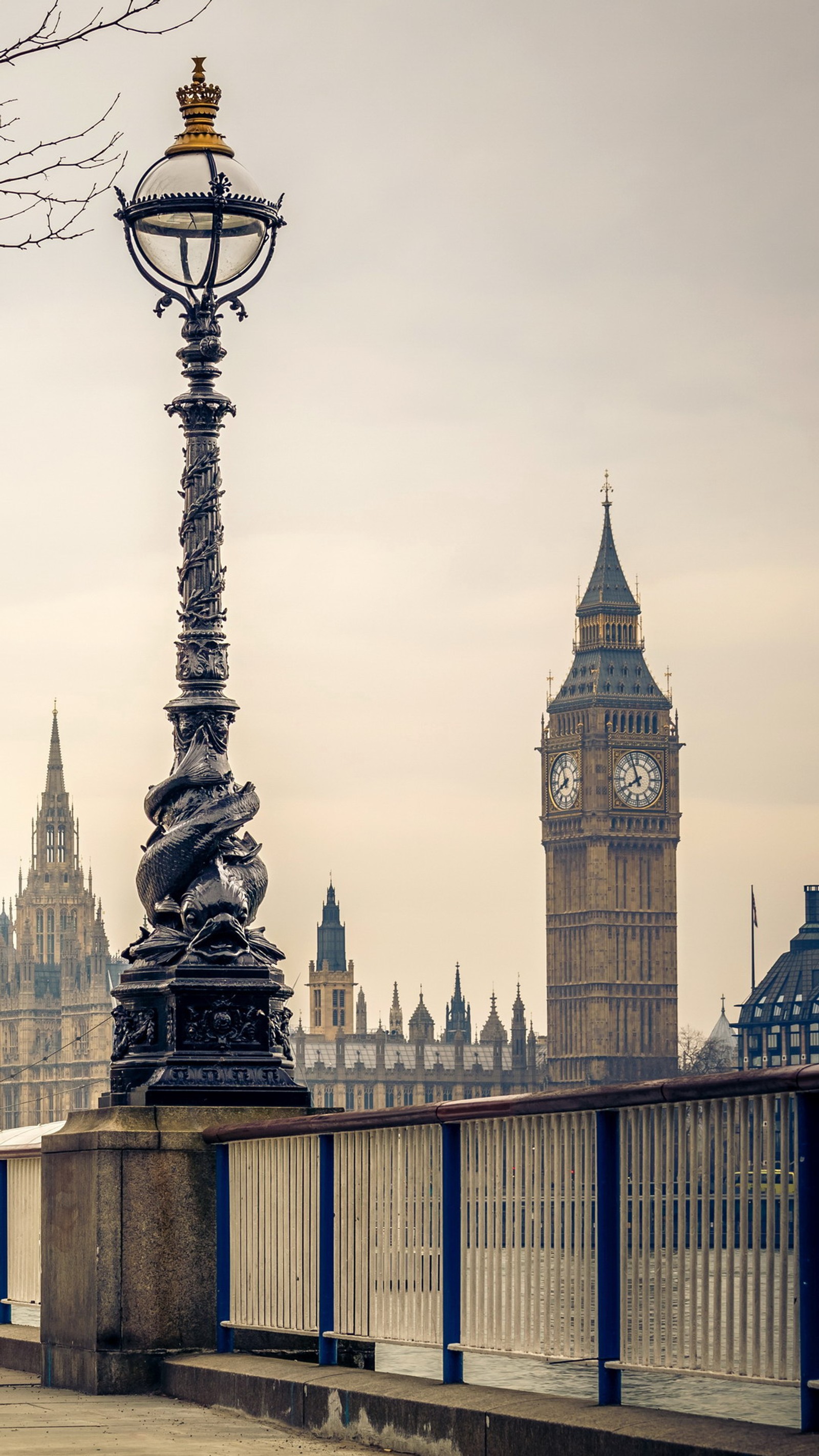 There is a clock tower in the distance with a clock on it (england, great brithany, london)