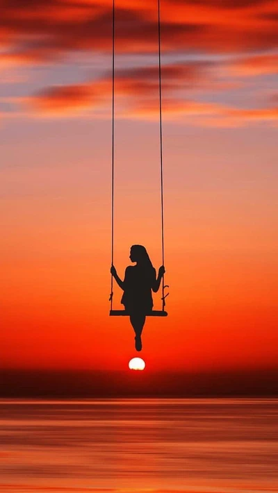 Menina em um balanço contra um pôr do sol vibrante