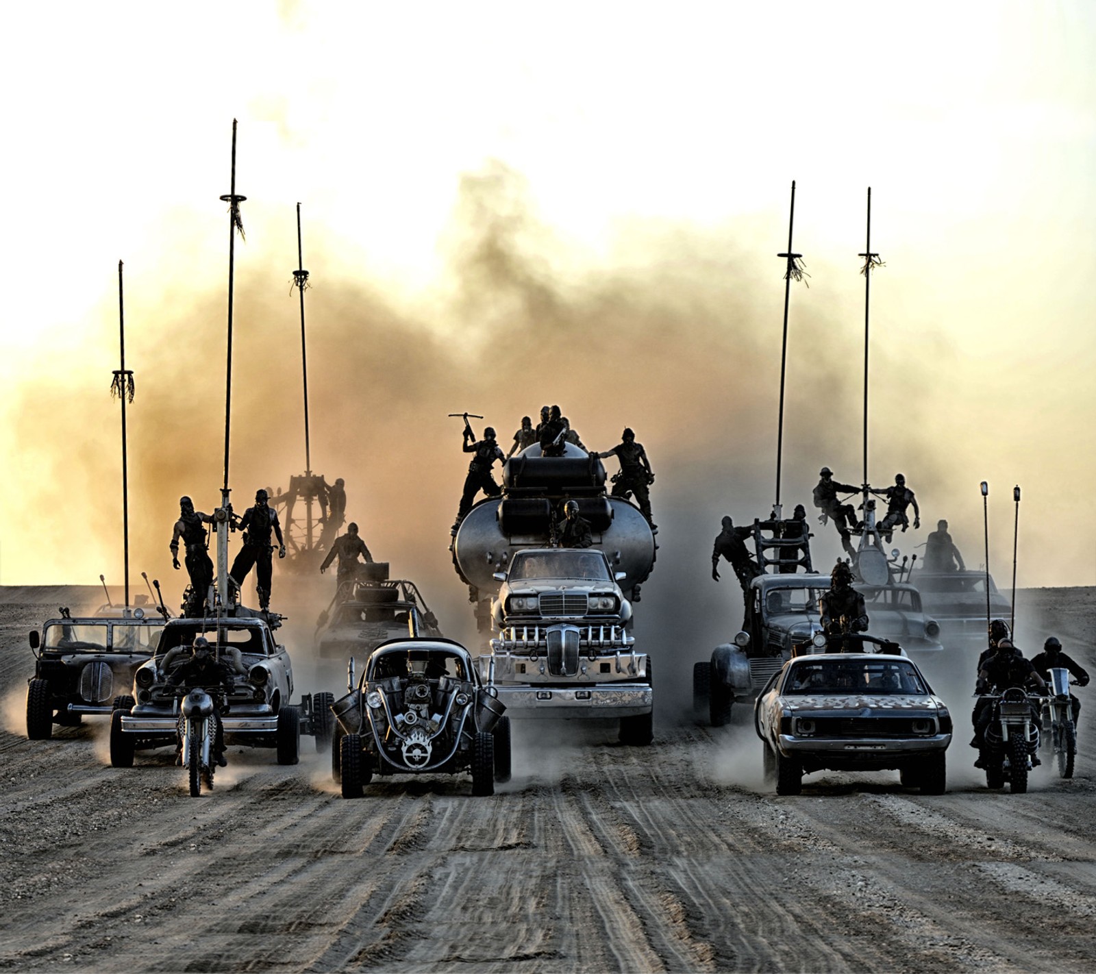 Mehrere fahrzeuge fahren auf einem schotterweg, auf denen menschen sitzen (fury road, mad max)