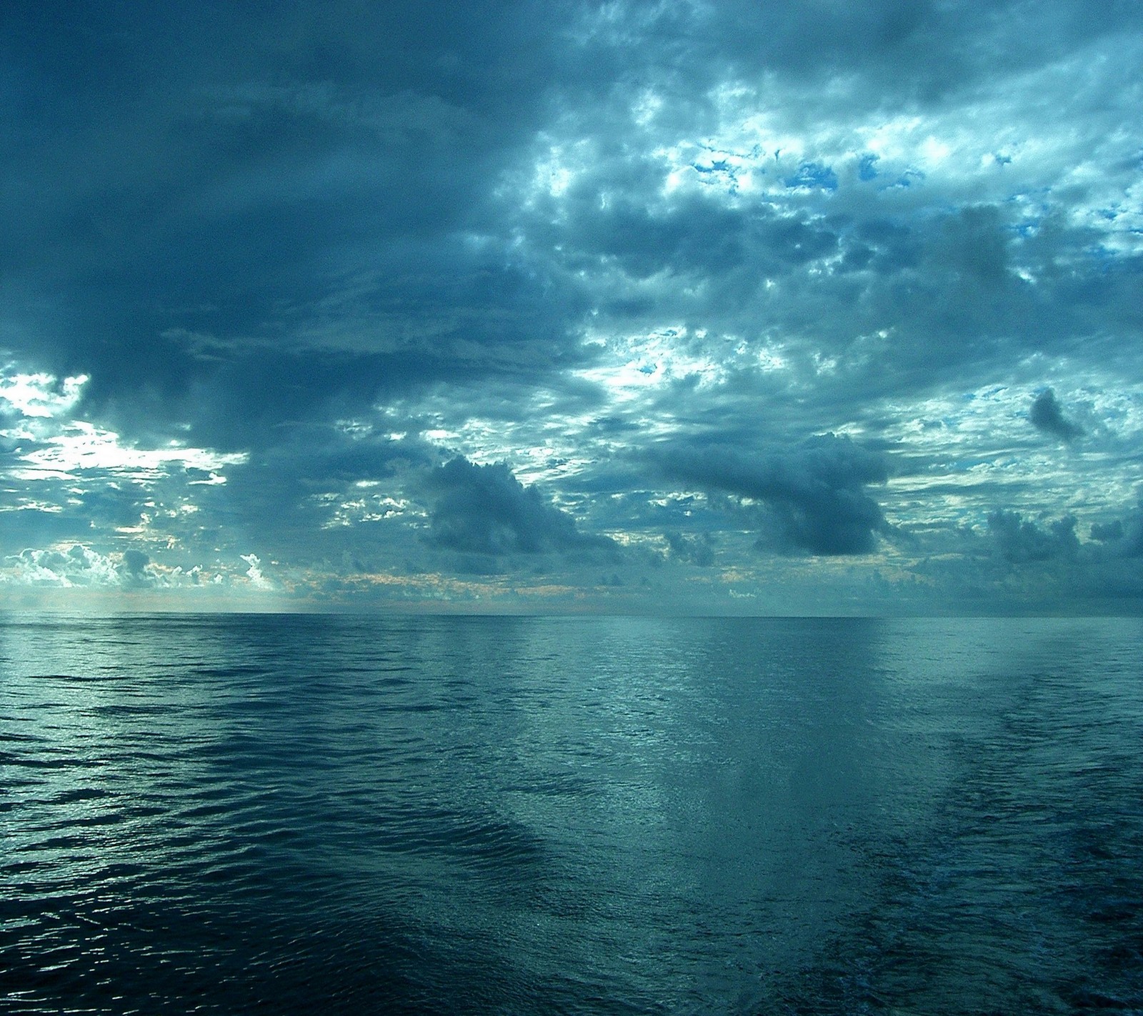 Arafed view of a body of water with a boat in the distance (cloud, nature, ocean, sea, shine)