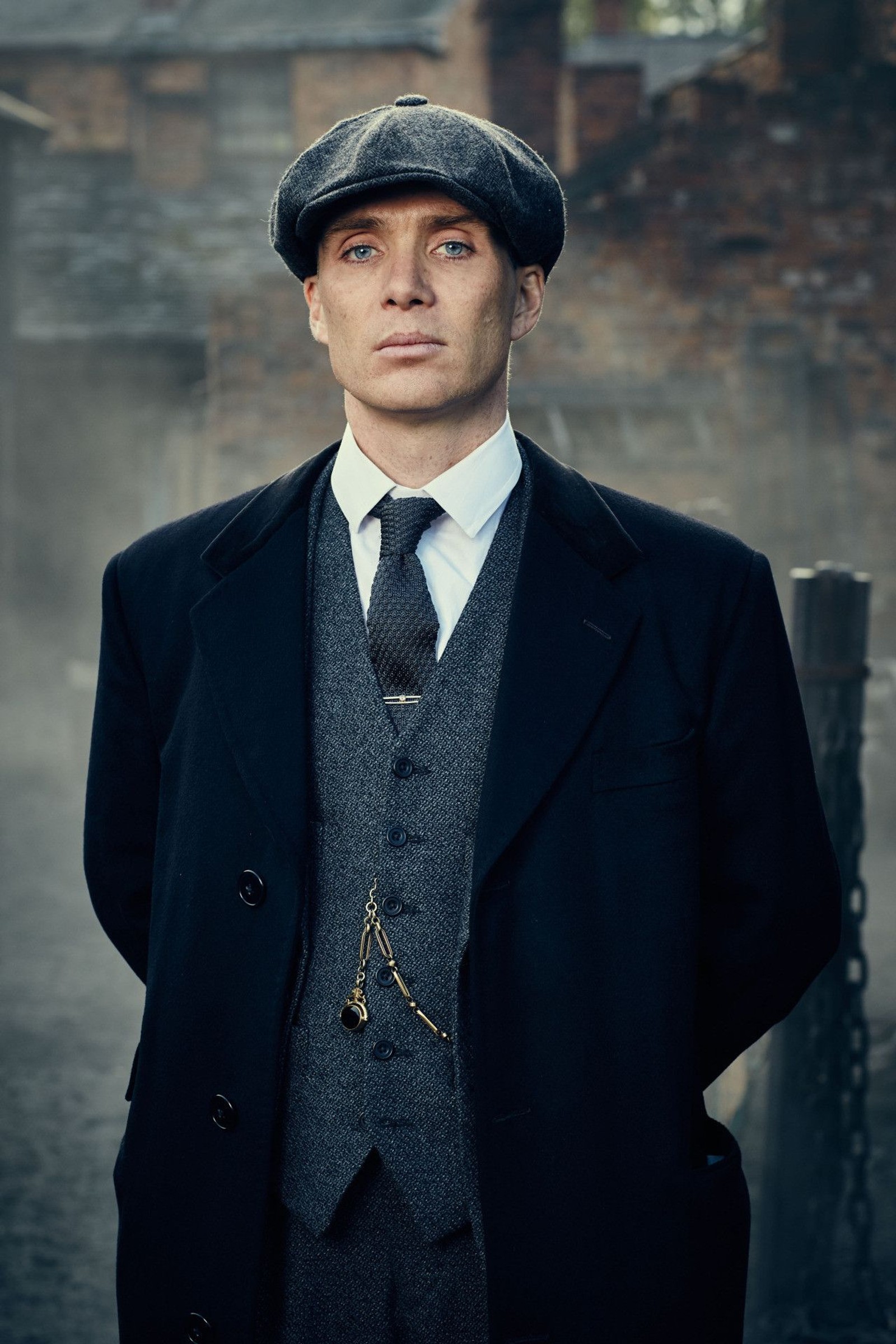 Un hombre en traje y corbata de pie en la calle (netflix, peaky blinders)