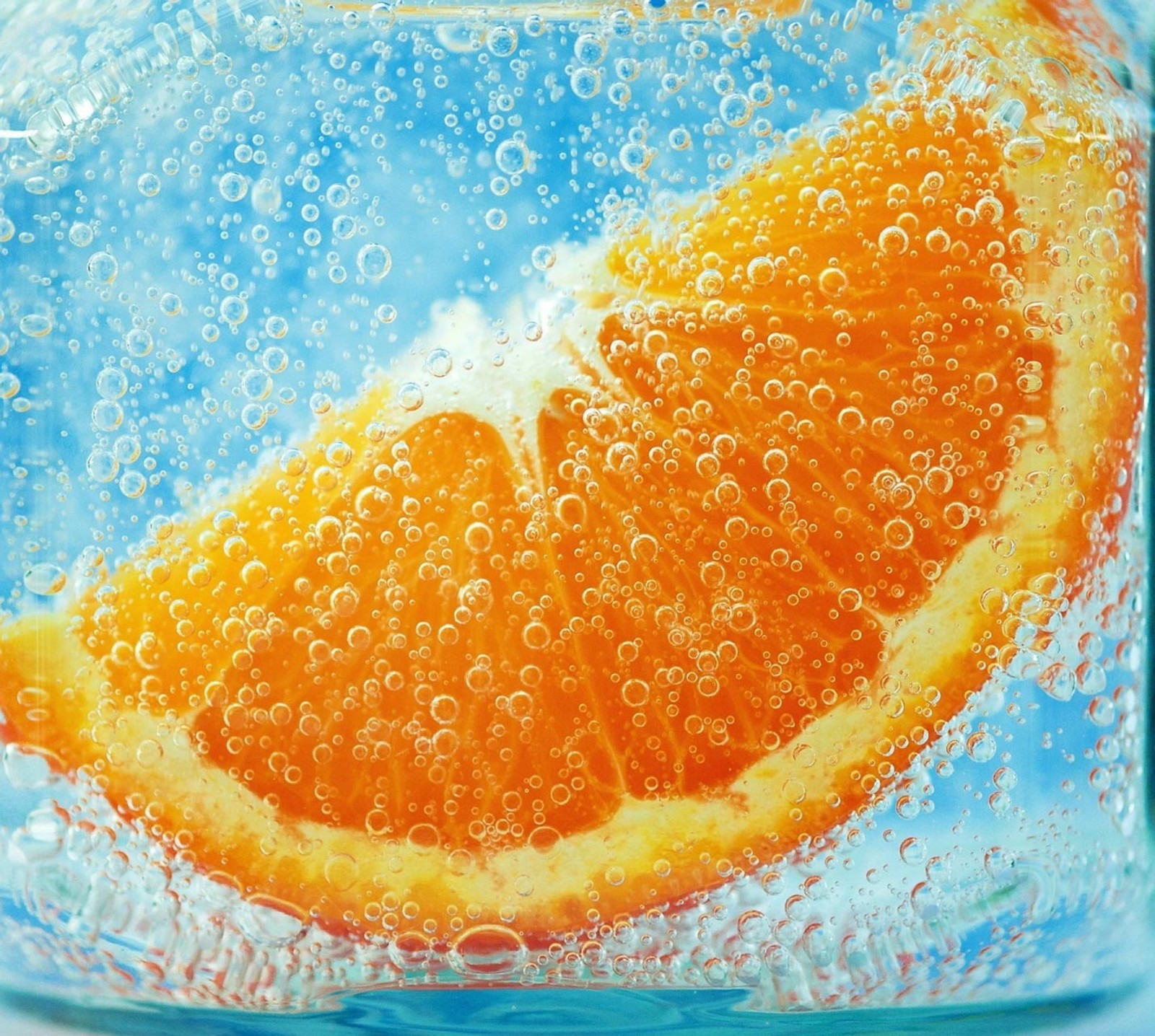 Hay una rodaja de naranja en un vaso de agua con burbujas (diseños, naranja)