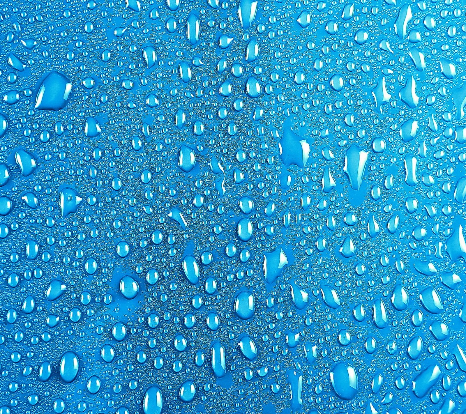 A close up of water droplets on a blue surface (blue, drops, water)