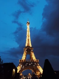 Torre Eiffel iluminada contra um céu noturno azul