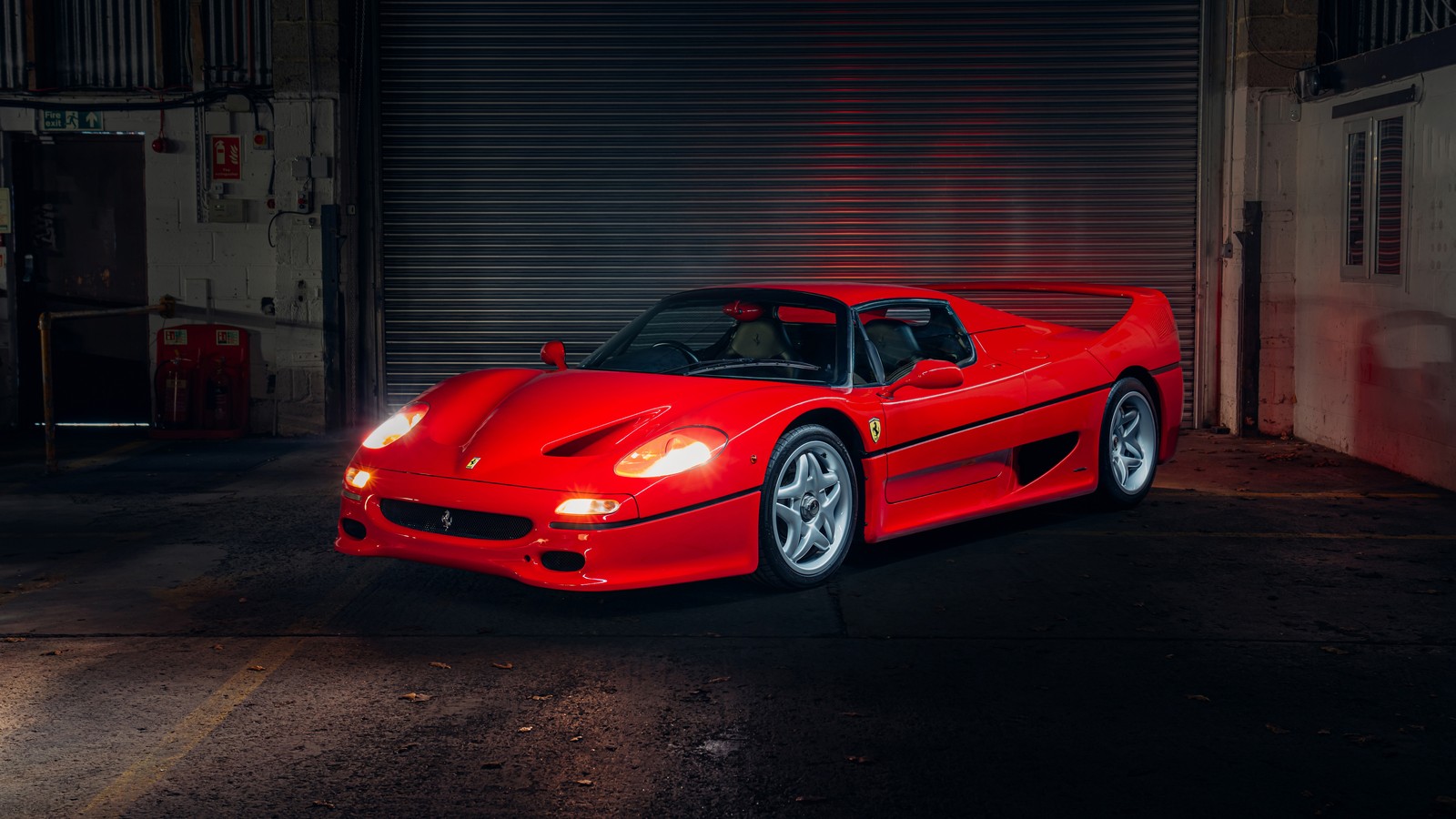 Eine nahaufnahme eines roten sportwagens, der in einer garage parkt (ferrari f50, superauto, rote autos, autos, 4k hintergrund)