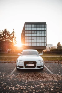 Audi Limousine mit stilvollen Felgen bei Sonnenuntergang in modernem Architektur-Setting