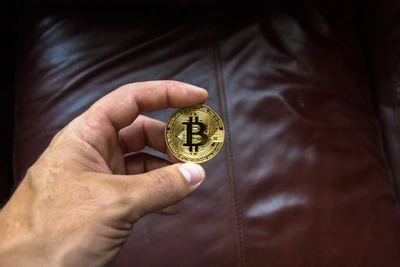 Main tenant un Bitcoin sur une surface en cuir