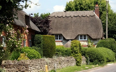 Encantadora casa de campo inglesa cercada por vegetação exuberante e uma parede de pedra