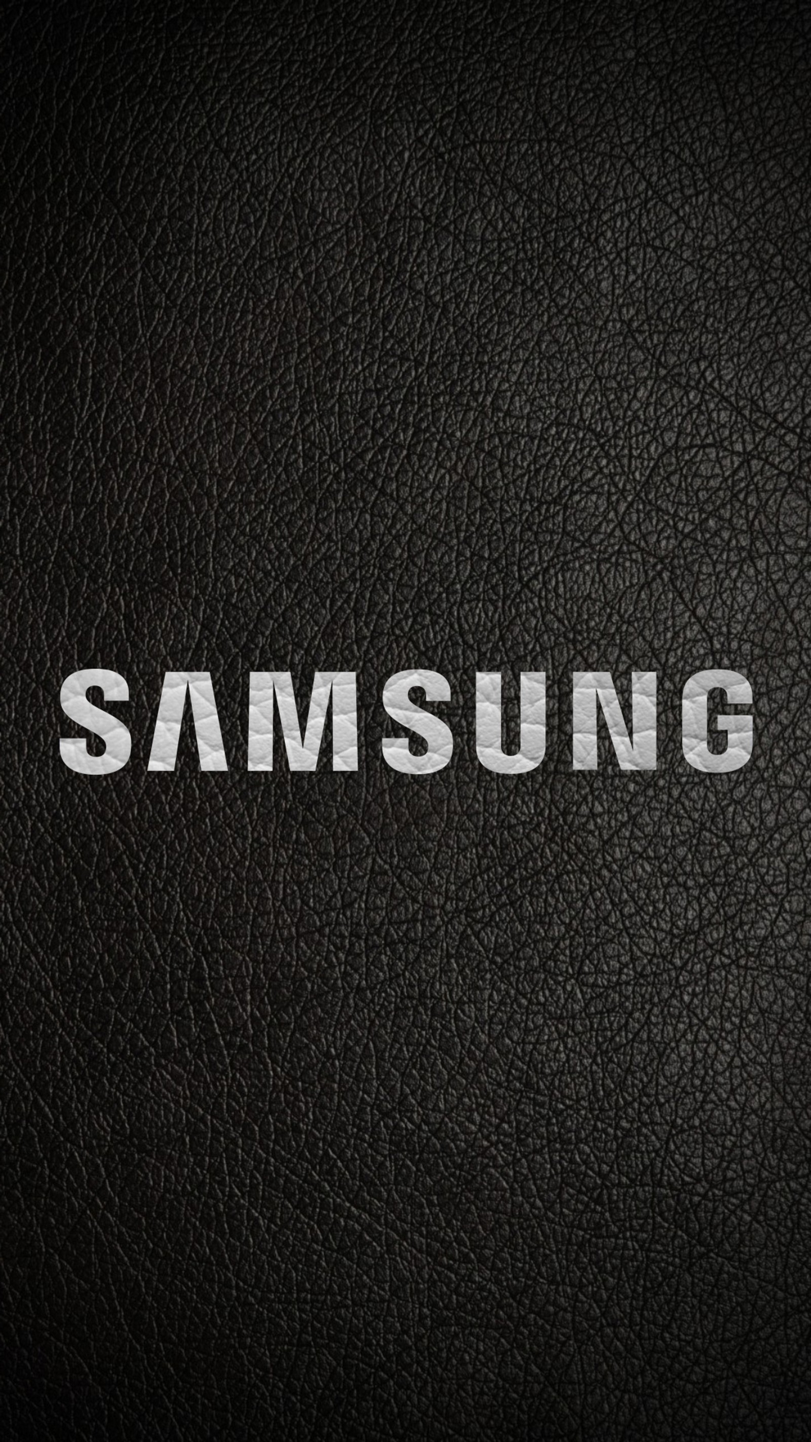 A close up of a black leather surface with the word samsung written on it (black, logo)