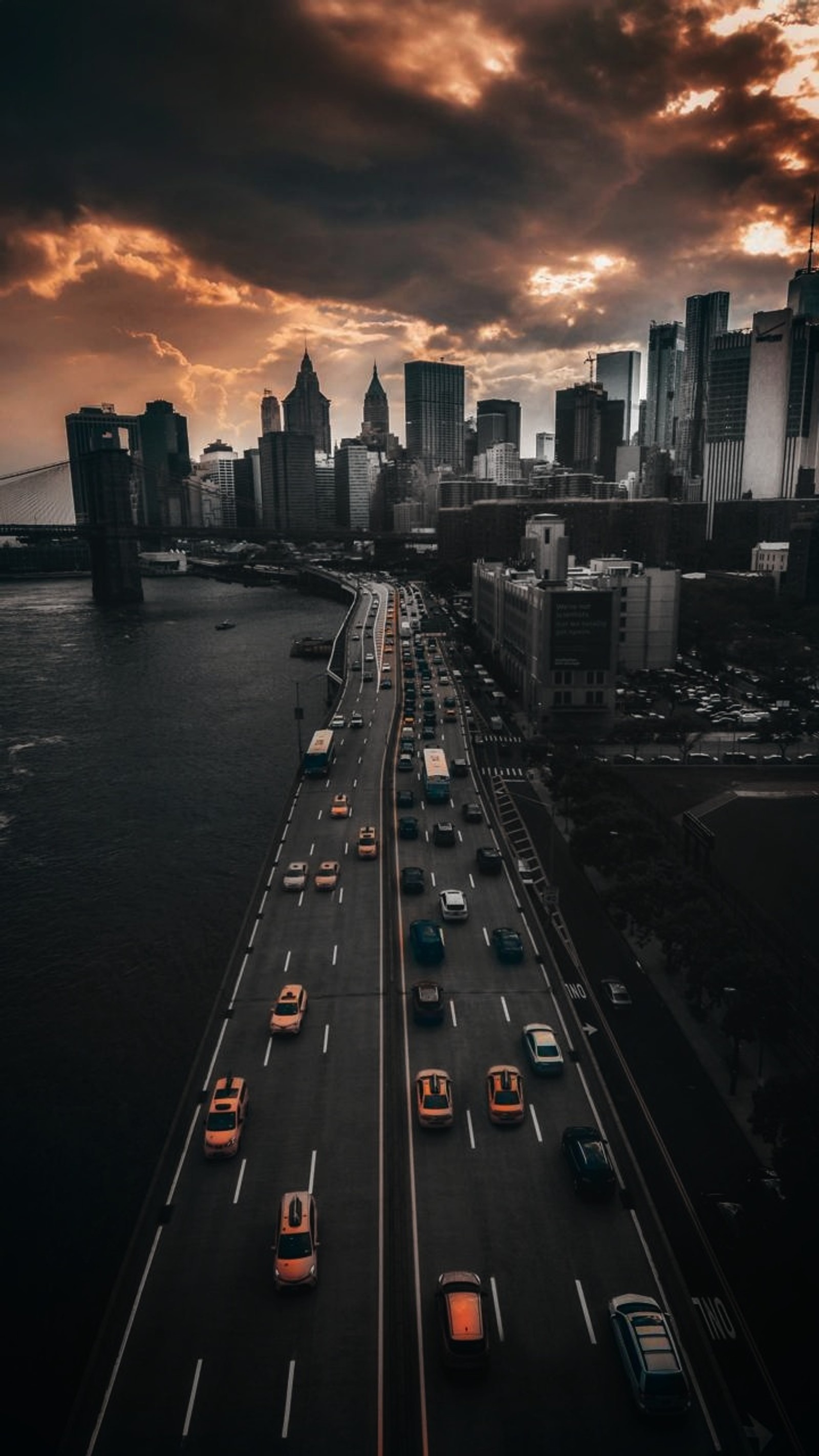 Une vue d'une autoroute avec des voitures circulant et une ville en arrière-plan (brooklyn, pont de brooklyn, ville, manhattan, new york)