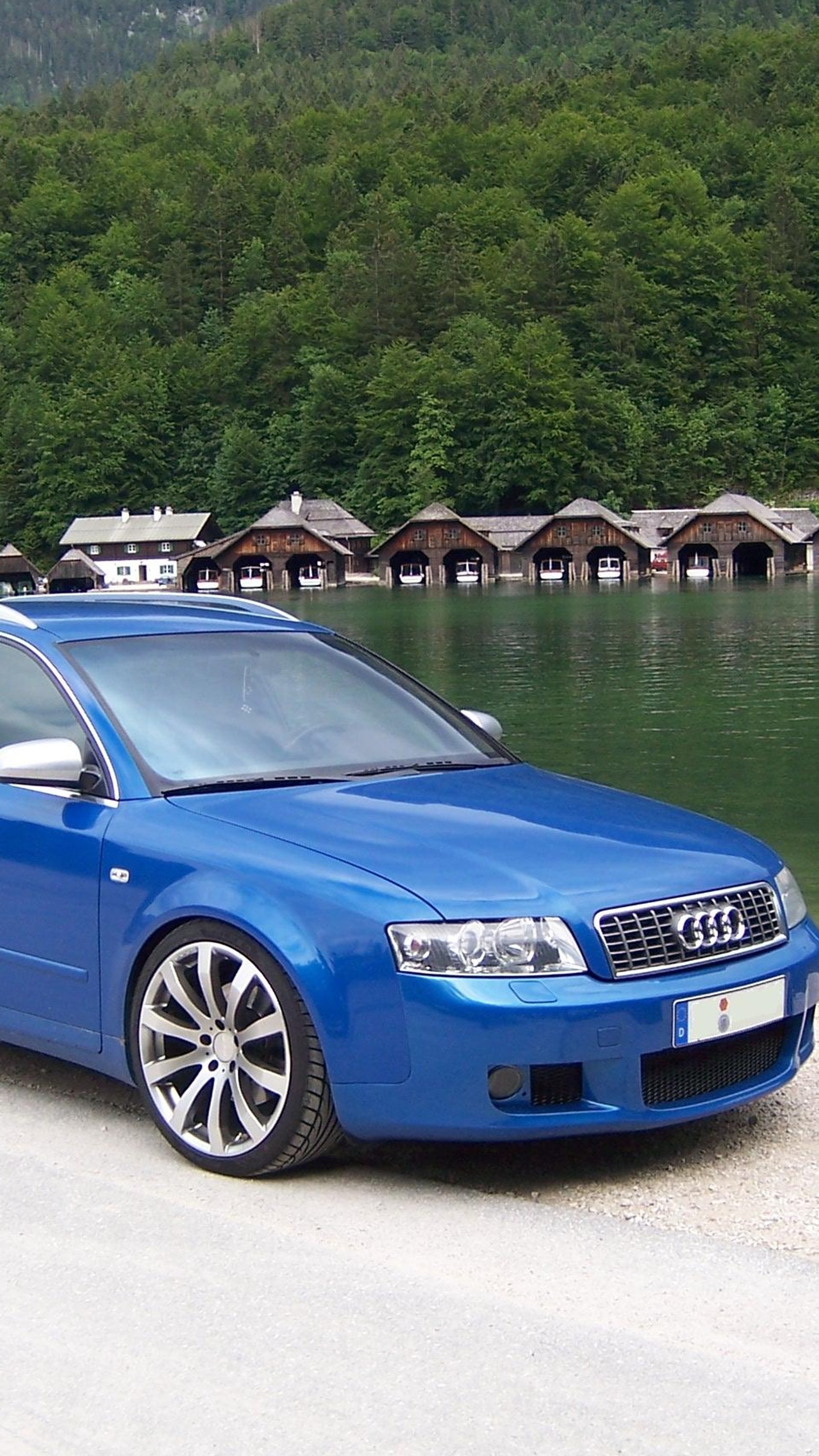 Ein blauer suv, der am straßenrand in der nähe eines sees parkt (a4, audi)