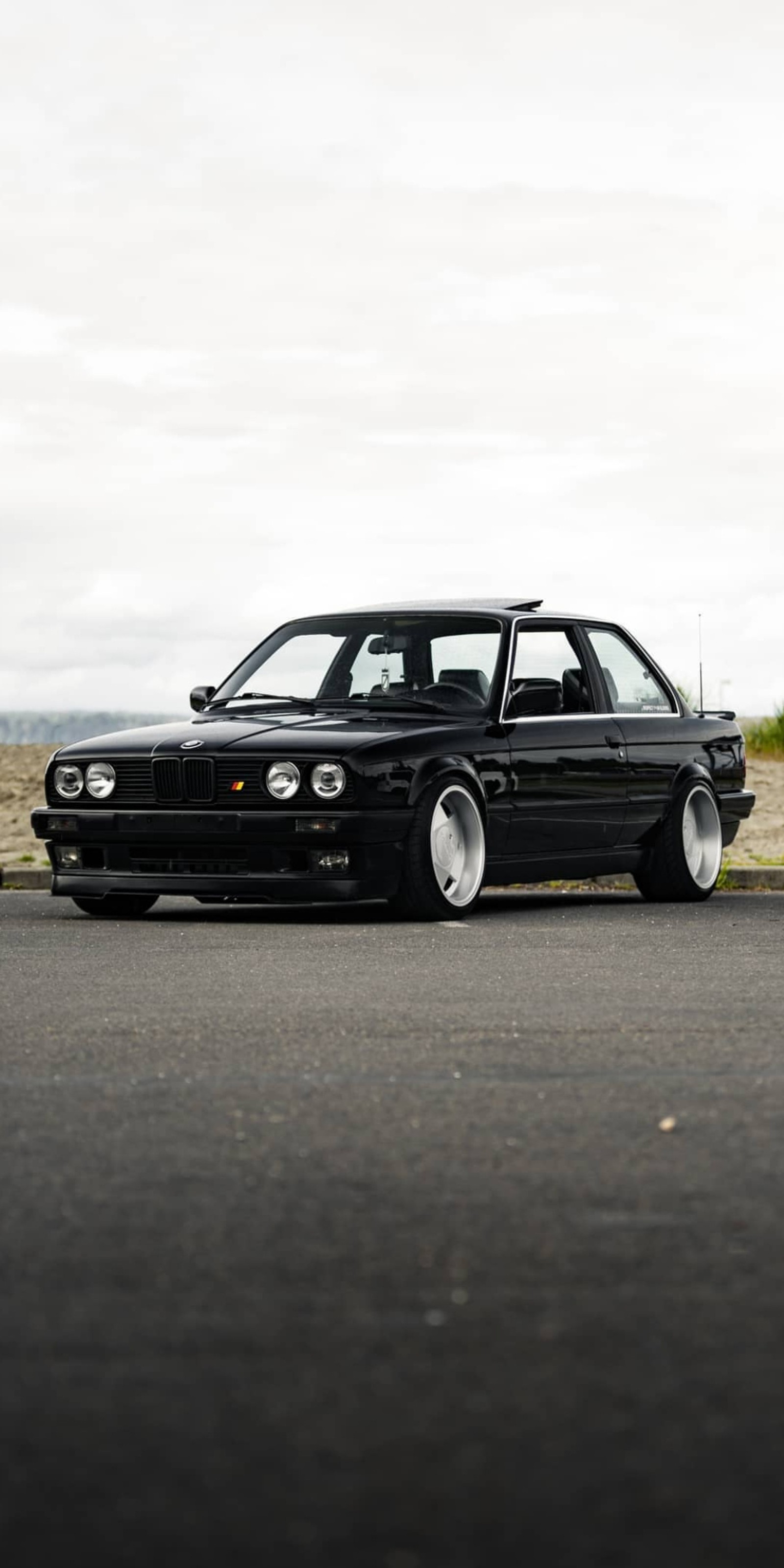 Hay un coche negro estacionado al lado de la carretera (coche, bimmer, negro, bmw, coches)