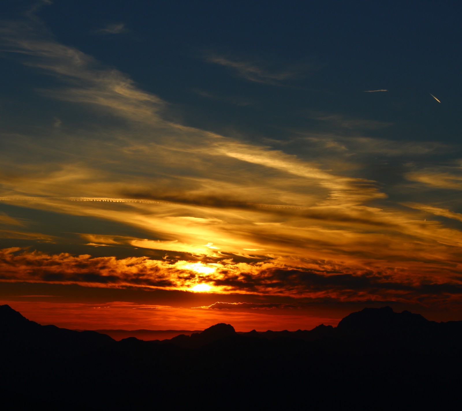 Arafed view of a sunset with a plane flying in the sky (beautiful, clouds, evening, red, sun)