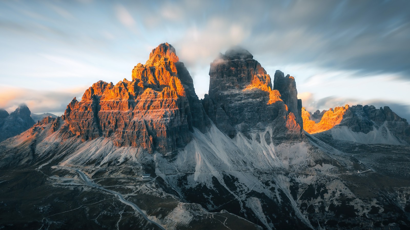 A mountain range with a few snow covered mountains in the background (mountain, mountains, scenery, tre cime di lavaredo, italy)