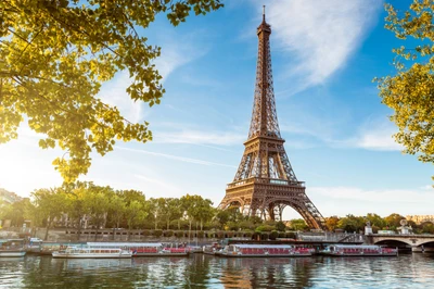 Tour Eiffel reflétée dans la Seine avec une végétation luxuriante et un ciel dégagé