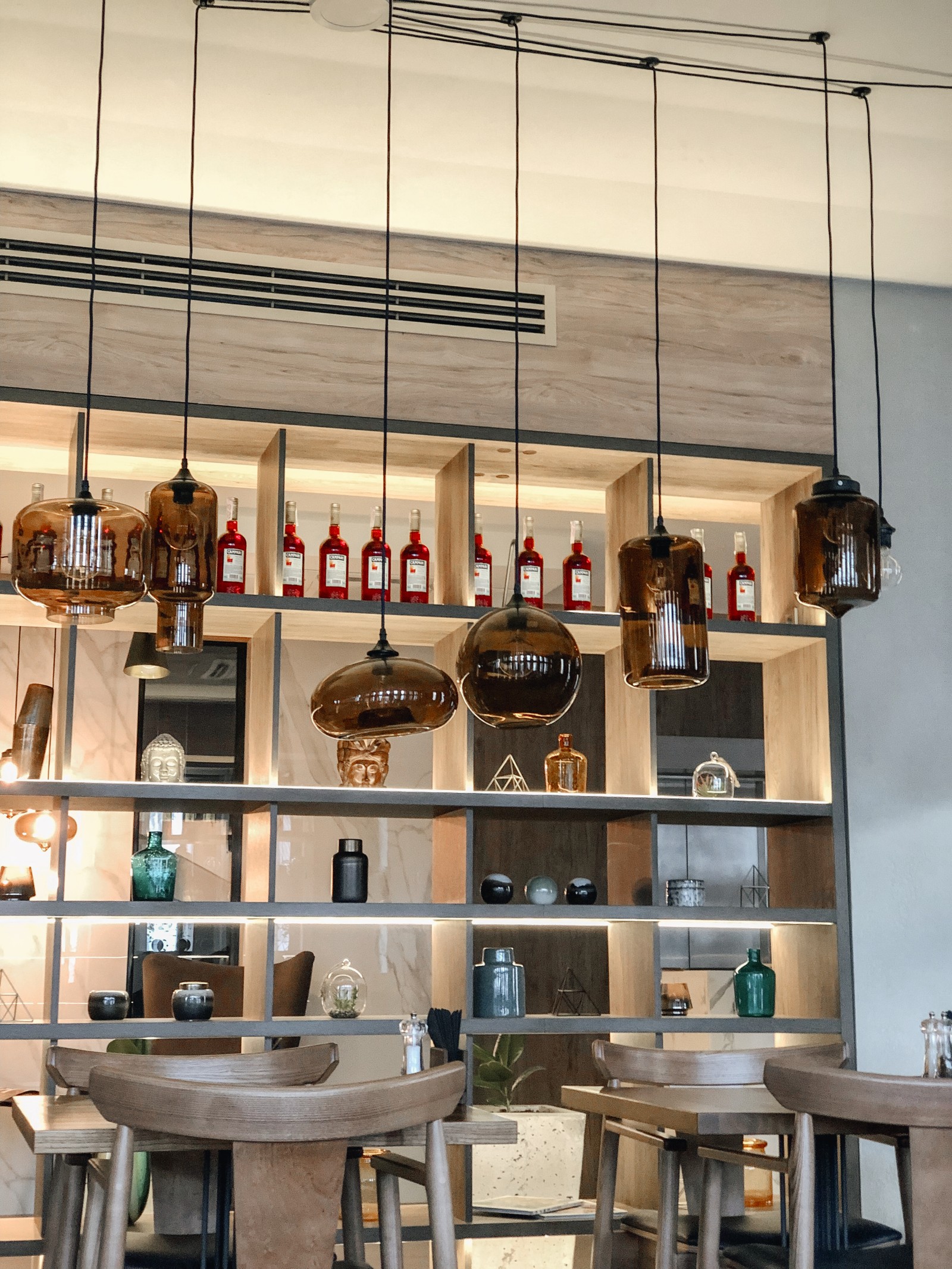 Há muitas garrafas de vinho nas prateleiras acima do bar (design de interiores, móveis, mesa, garrafa, coleção)