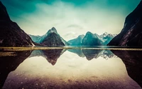 Majestuosas montañas reflejadas en las tranquilas aguas de un fiordo.