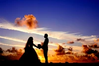 Couple en silhouette s'embrassant lors d'une proposition romantique au coucher du soleil