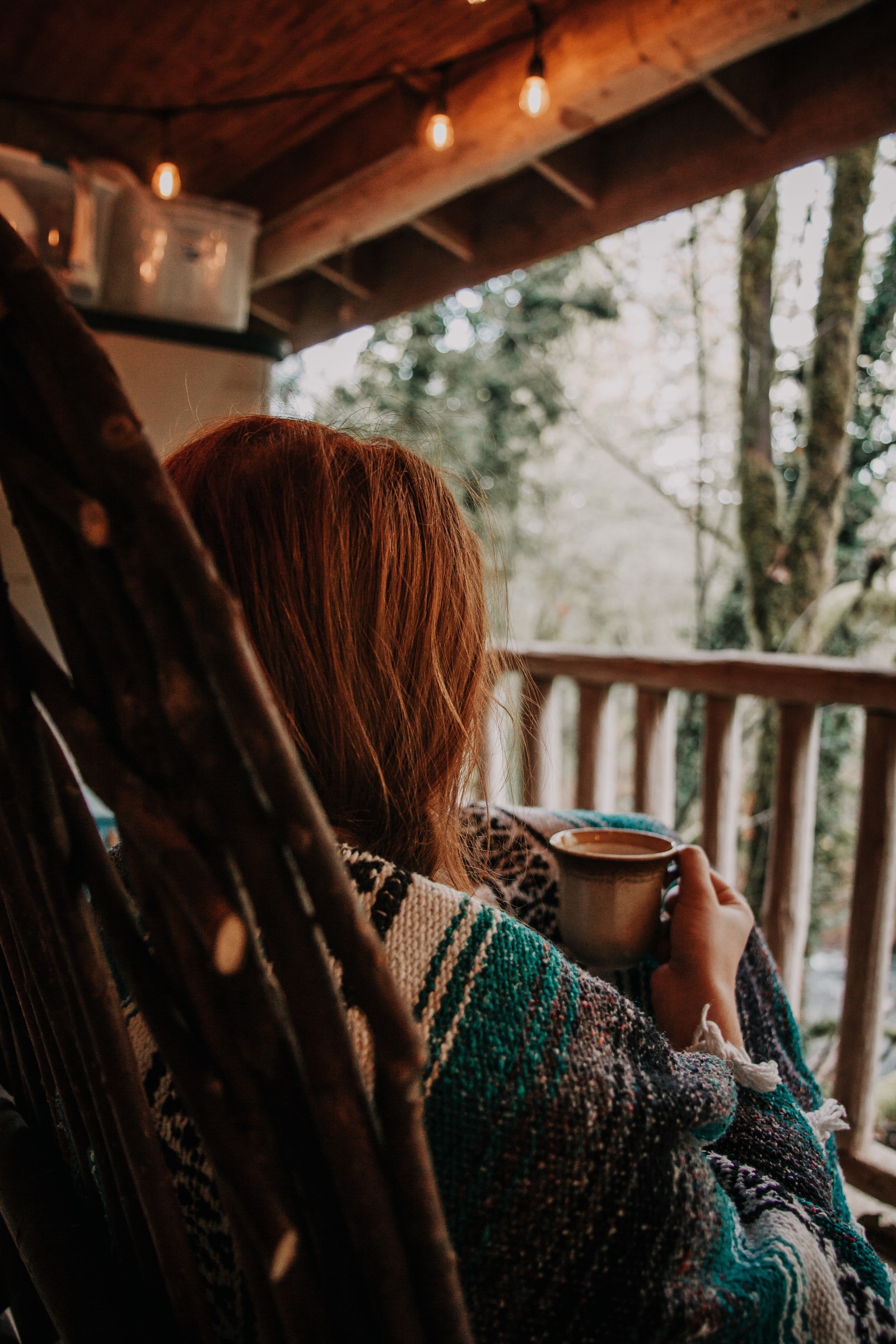 Araffe sitting in a rocking chair with a cup of coffee (hair, beauty, tree, long hair, sunlight)