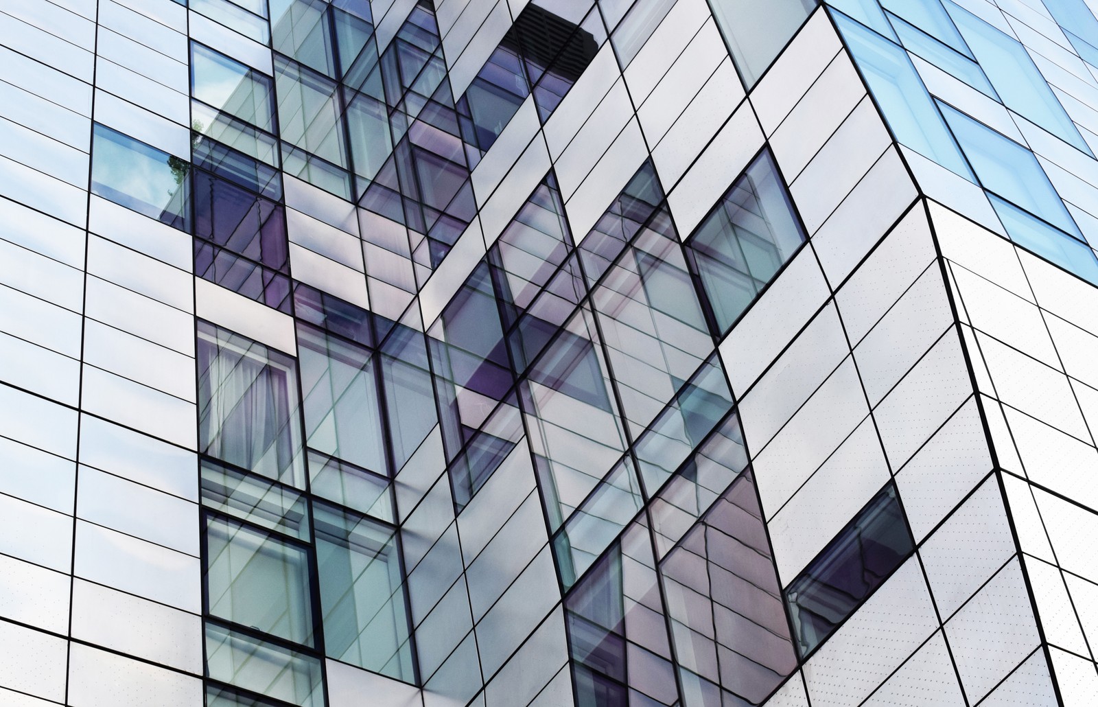 Vista de un edificio con un reloj en el exterior (arquitectura, día, edificio comercial, edificio, vidrio)