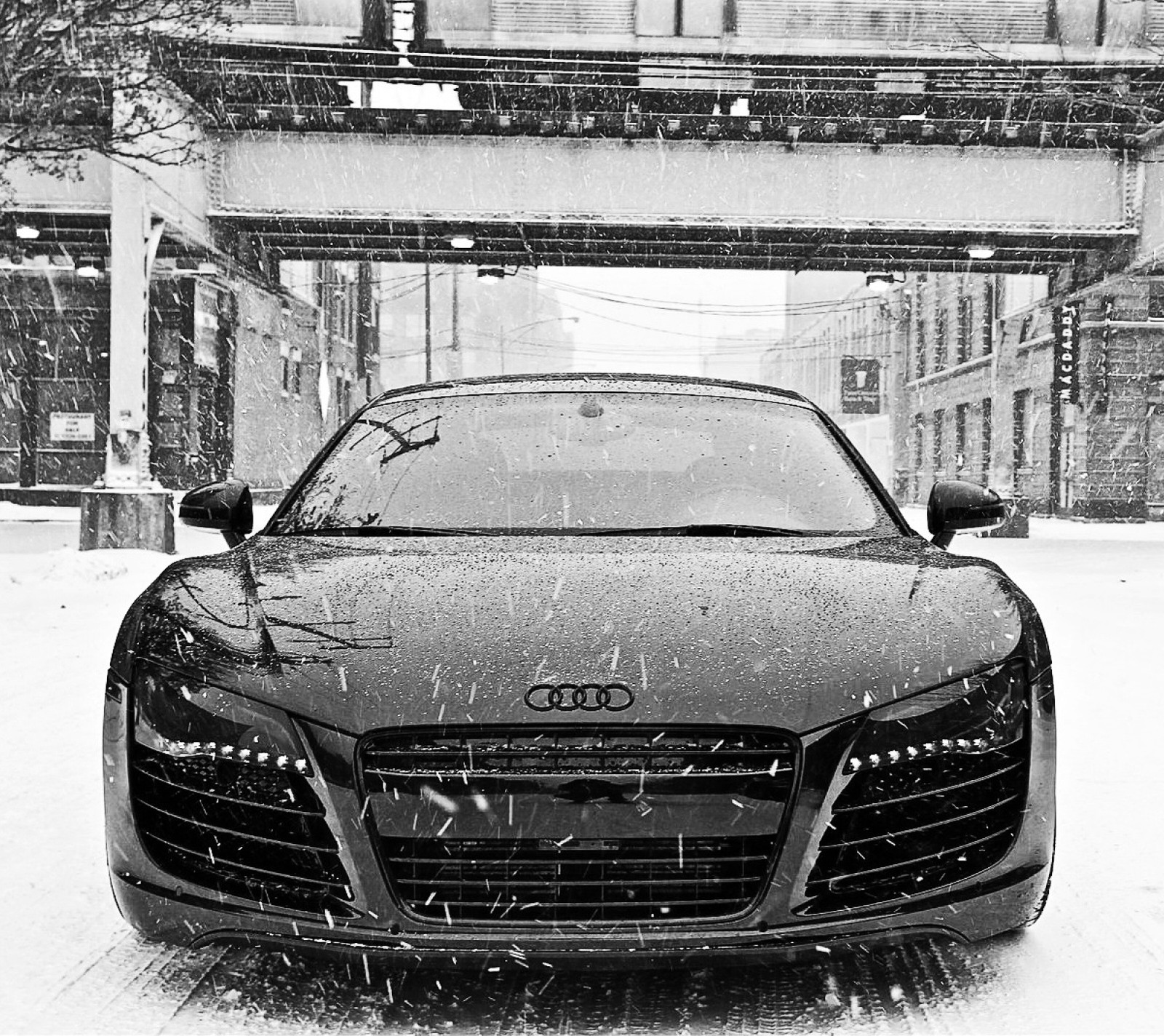 A close up of a car parked in the snow on a city street (audi r8, hyper black, snow, v10)