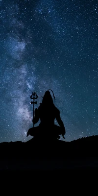 Silhouette du Seigneur Shiva contre un ciel nocturne étoilé.