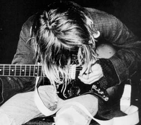 Kurt Cobain sumergido en la creatividad cruda con su guitarra, capturando la esencia del espíritu de Nirvana.