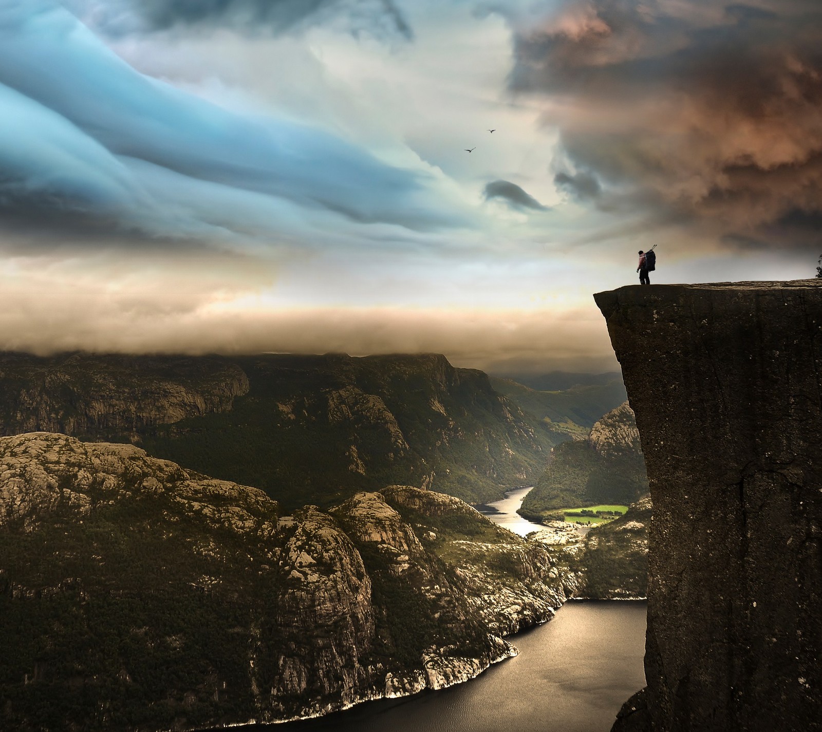 There is a man standing on a cliff overlooking a river (4k, hd, land, man, nature)