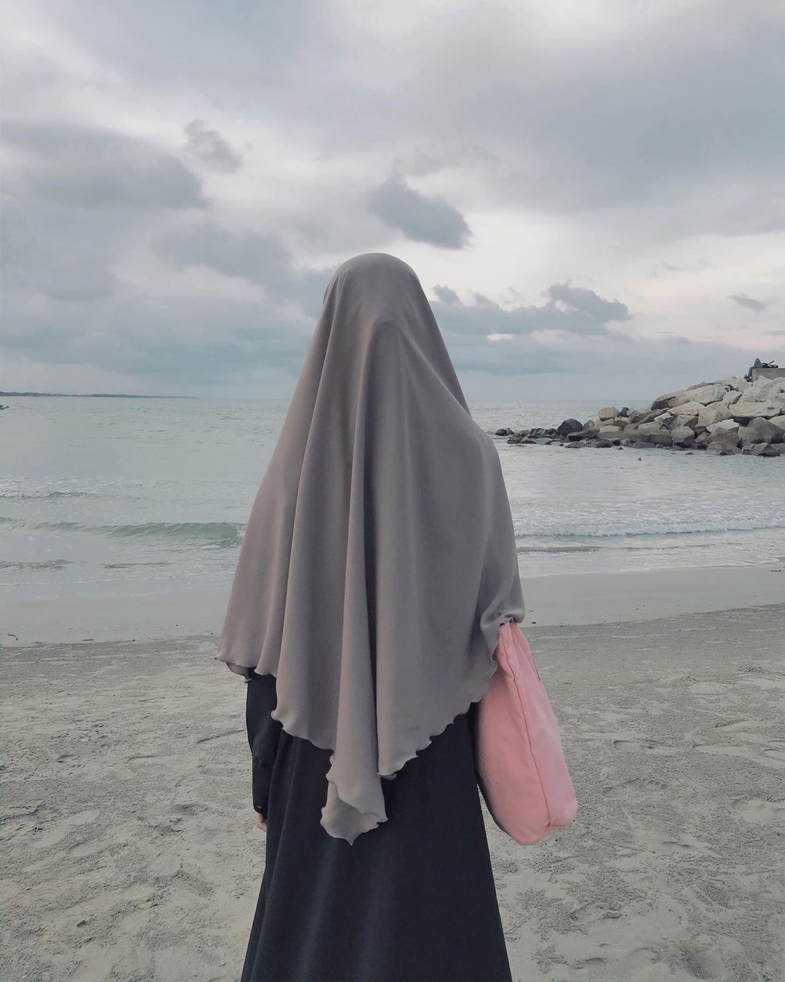 Eine frau in einem schwarzen und grauen hijab am strand (islamisch, populär, frauen)