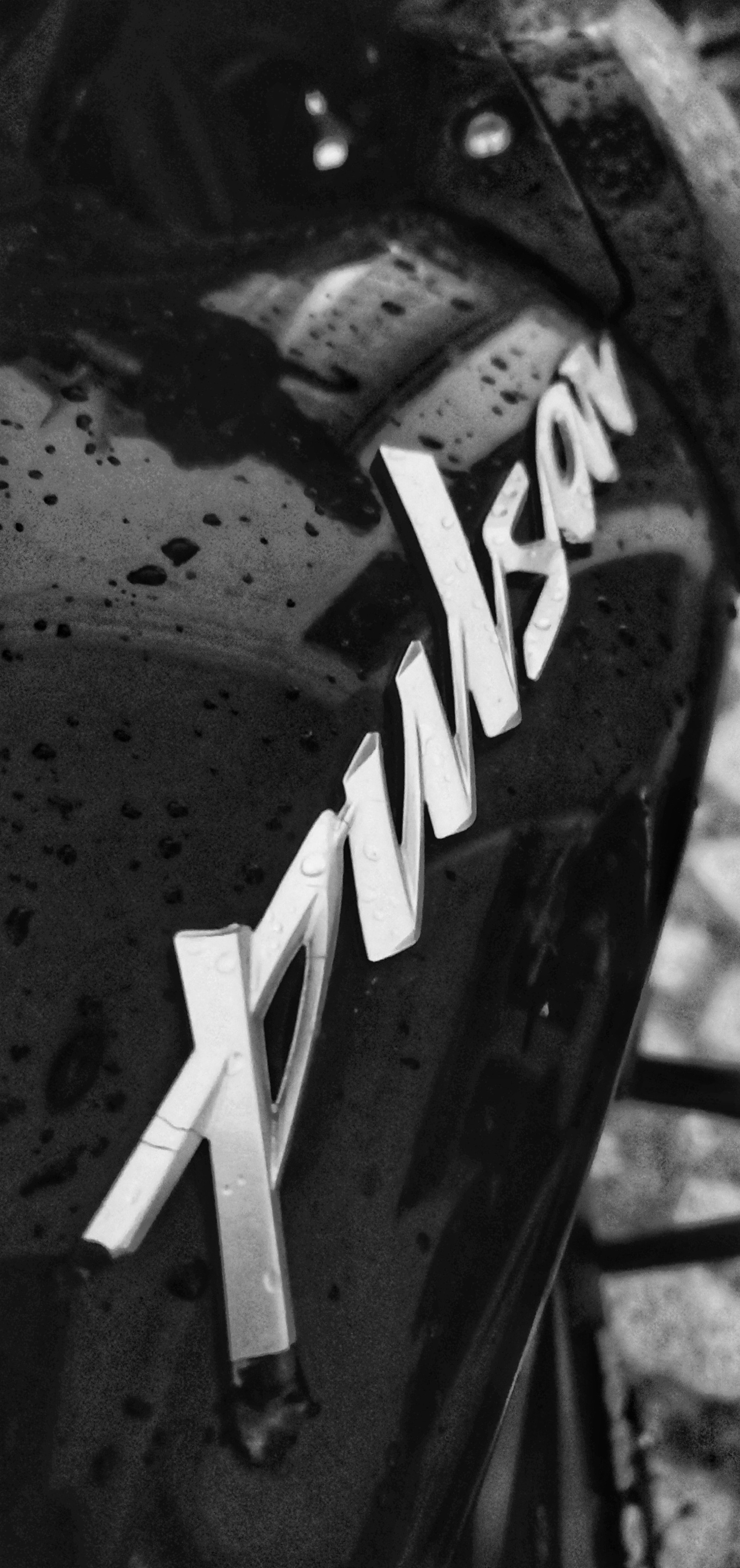 A close up of a black and white photo of a car with a name on it (logo, shot on oneplus 6)