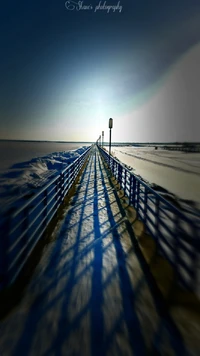 Píer nevado com longas sombras sob o sol de inverno