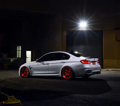 BMW F80 M3 Sedán blanco con ruedas de tuning rojas en un entorno urbano