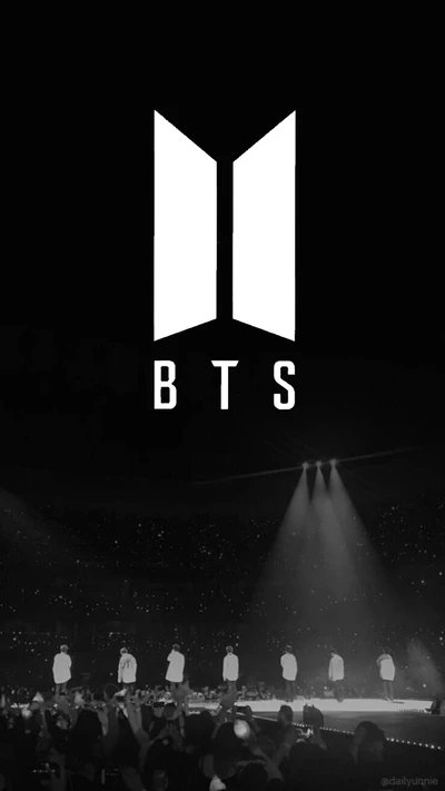 Logo de BTS con fondo de estadio oscuro y efectos de escenario