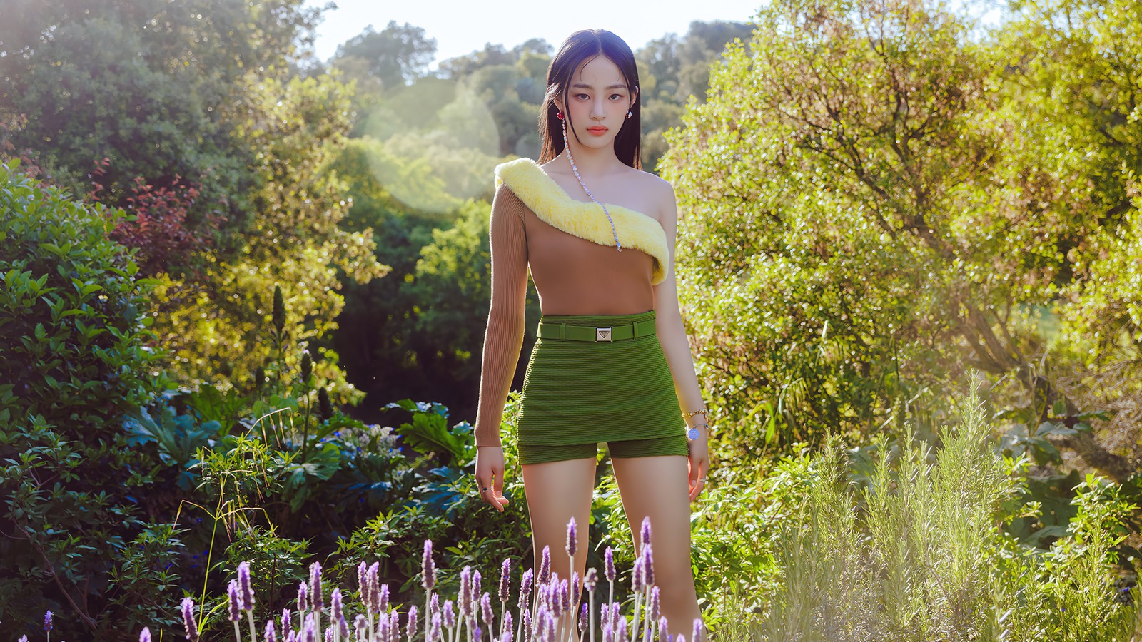 Femme modifiée en jupe verte et haut jaune se tenant dans un champ de fleurs (newjeans, kpop, groupe de filles coréen, korean girl group, k pop)