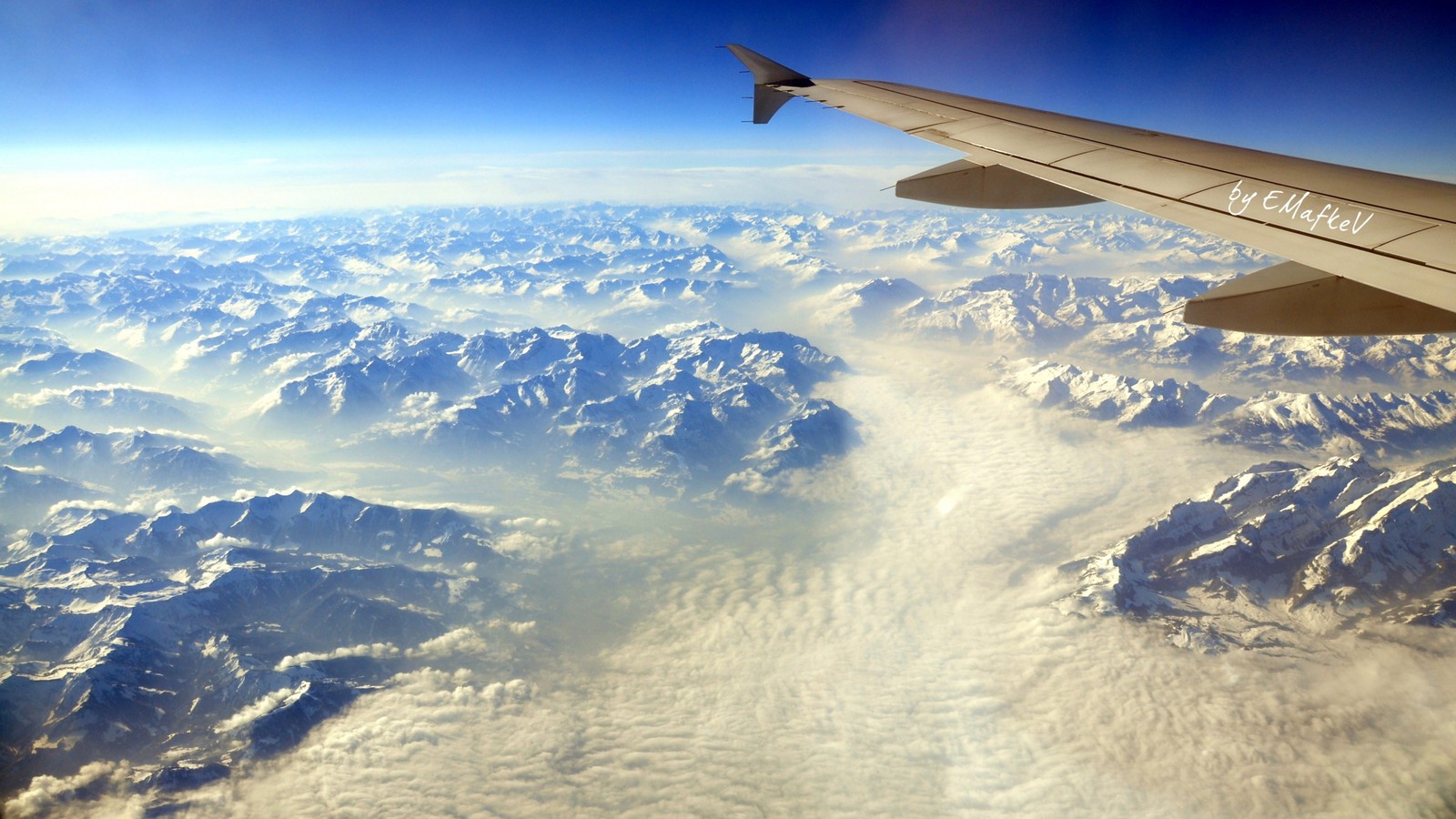 Arafed view of a plane wing flying over a mountain range (air travel, mountain range, atmosphere, mountainous landforms, mountain)