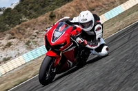 Honda CBR1000RR motorcycle racing on a racetrack, showcasing high-speed cornering.