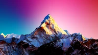 Majestic Alpine Summit at Sunrise with Vibrant Sky and Snow-Capped Peaks