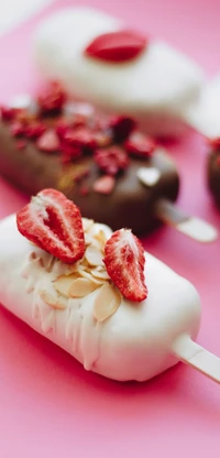 Leckere Eisriegel, verziert mit Schokolade, frischen Erdbeeren und Mandelstückchen auf einem lebhaften rosa Hintergrund.